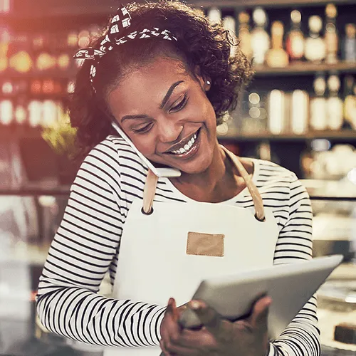 Restaurant owner taking a reservation over the phone and entering that reservation into Hostme restaurant management system